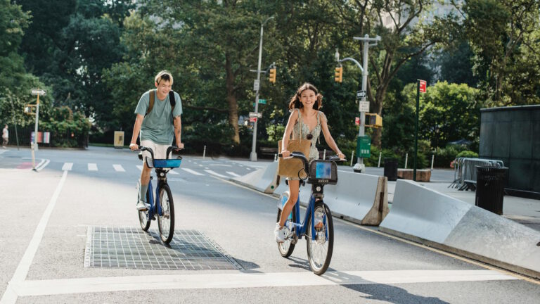 Zwei fröhliche Menschen, die auf Fahrrädern durch die Stadt fahren