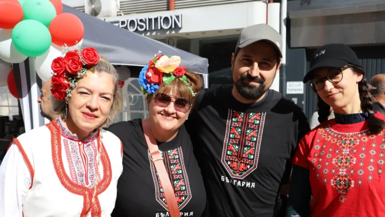 Vier Menschen unterschiedlicher Herkunft und verschiedenen Alters lächeln fröhlich. Sie tragen traditionelle Ukrainische Tracht und genießen sichtlich das interkulturelle Fest.